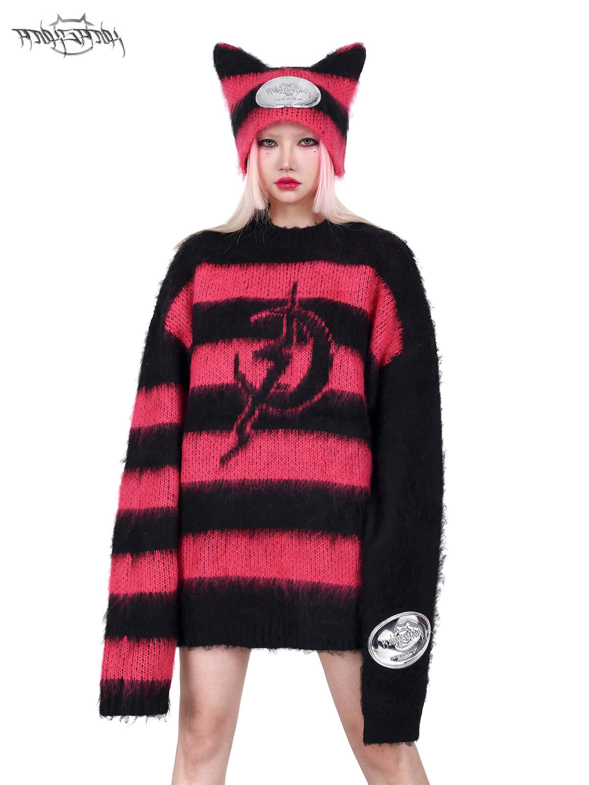 PINKSPINK ELECTRIC MOON black-pink striped sweater in black pink — front three-quarter modeled view with one hand at the coordinating hat