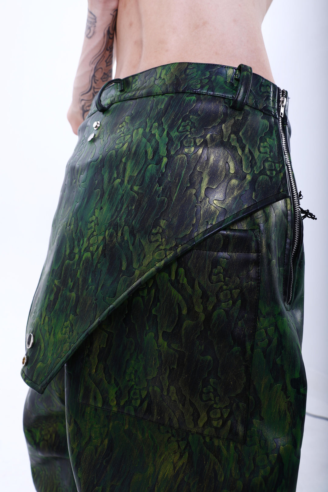 EMBRYO TRIANGLE ARMOR lace-inset leather pants in green — rear three-quarter hip detail showing the patch pocket