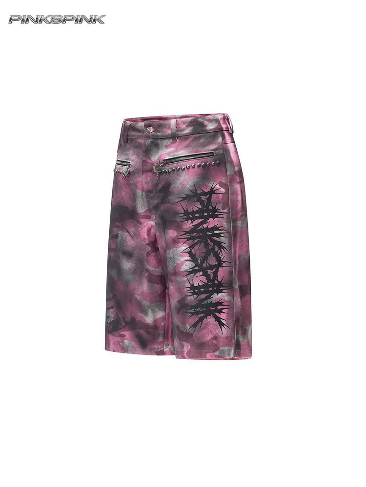 PINKSPINK ELECTRIC MOON coated camouflage denim shorts in pink-gray camouflage — angled garment-only front view showing thorn graphics