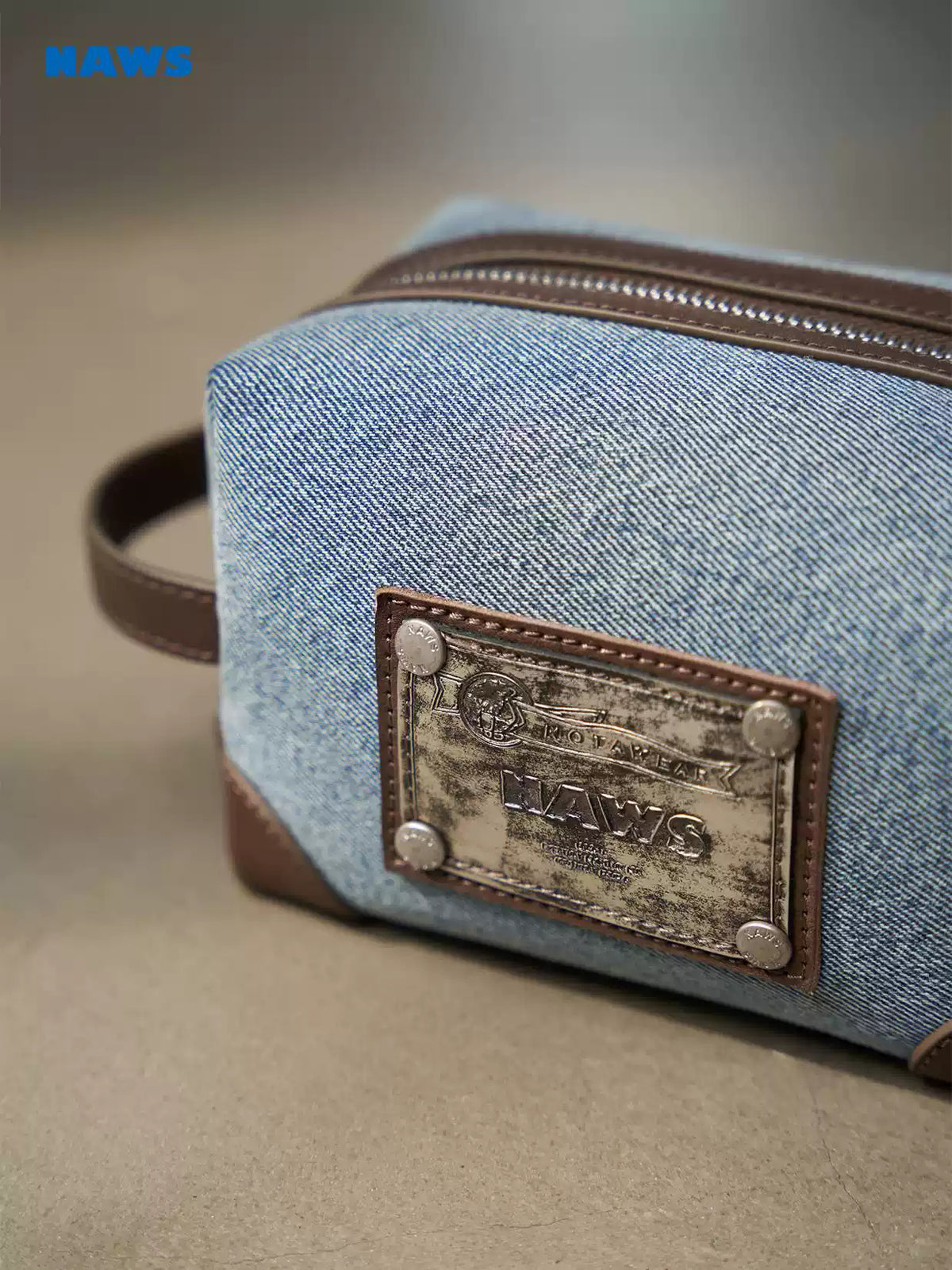 NAWS BLUE BOX denim makeup bag — modeled front styling view