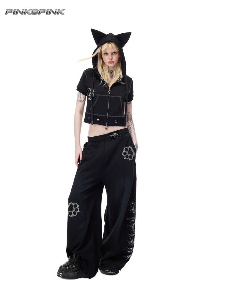 PINKSPINK CATPAW rhinestone curved-leg sweatpants in black — full-length angled front modeled view with a separate cropped hoodie