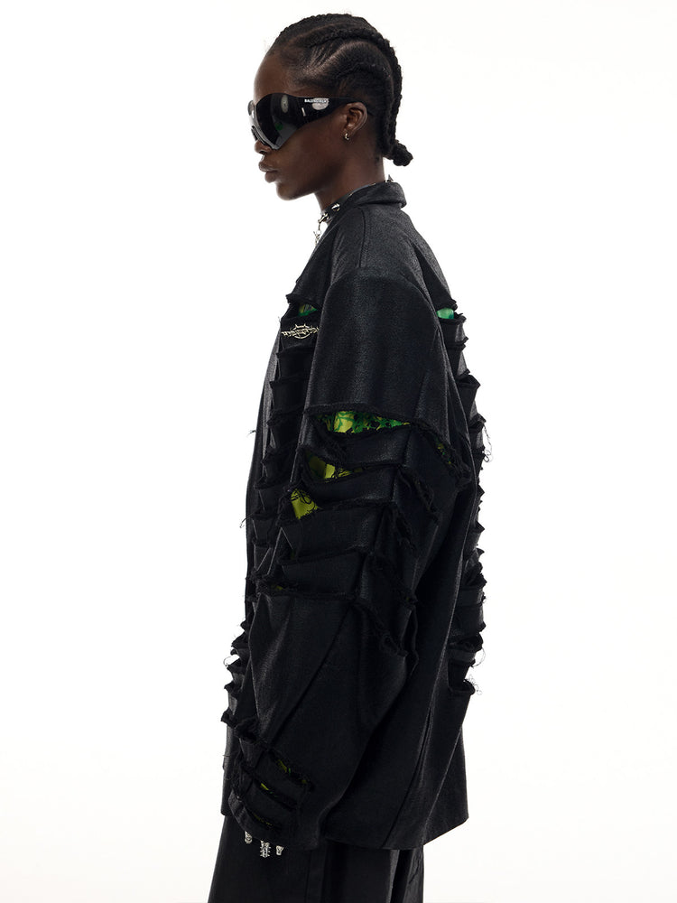 PINKSPINK BREACH distressed coated oversized blazer in black — side modeled detail showing the slashed sleeve and printed underlayer