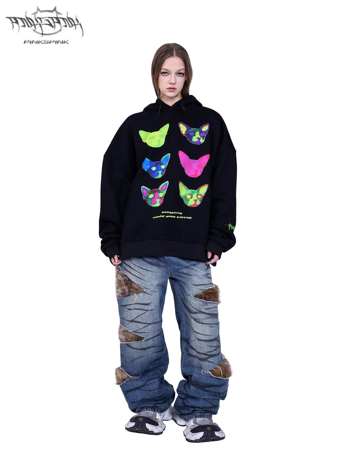 PINKSPINK SCRATCH leopard-panel layered jeans — modeled front view with a black cat-print sweatshirt and sneakers