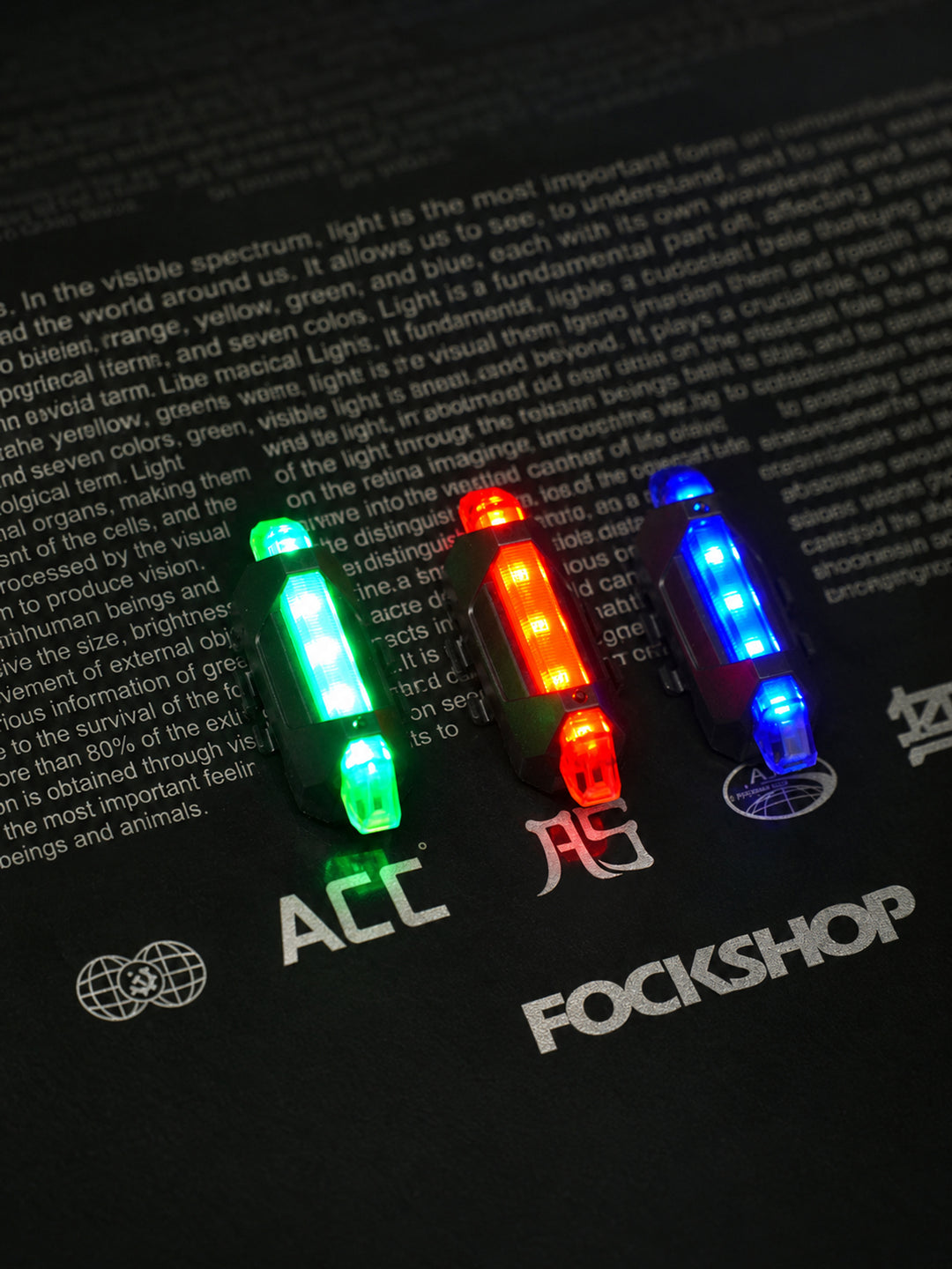 FOCKSHOP TRAIN L rechargeable costume light pair — overhead comparison of red, blue and green light colors