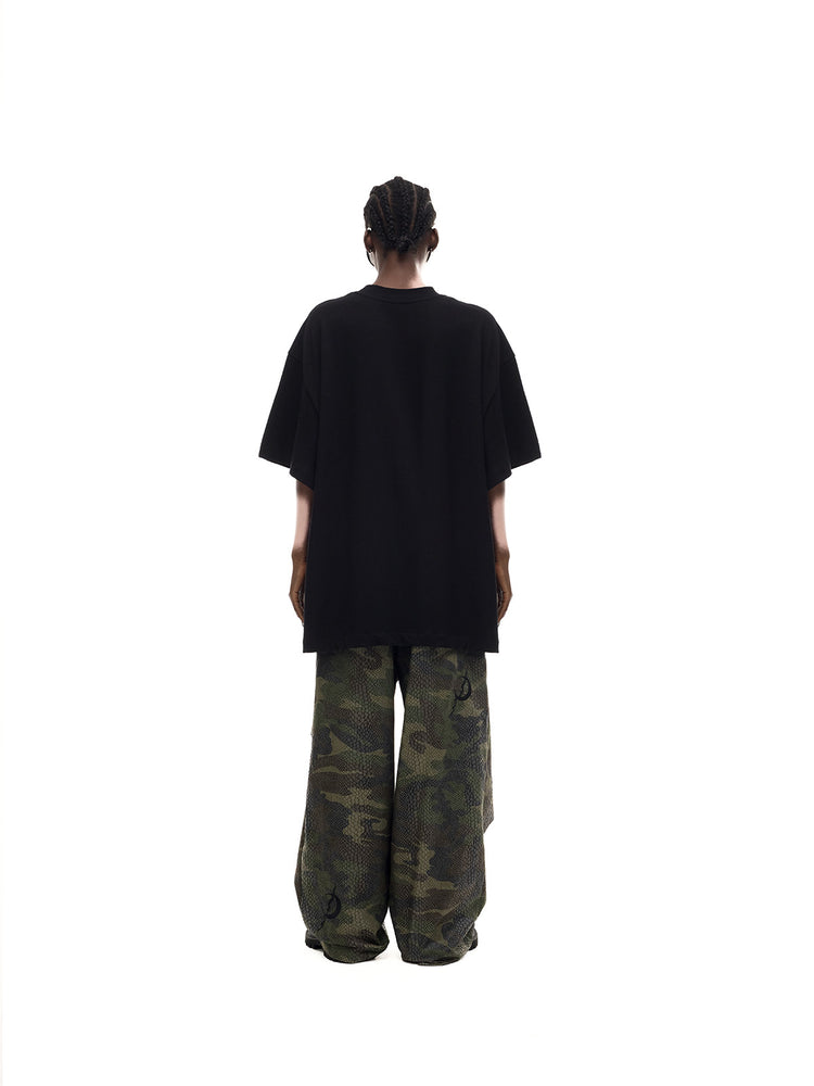 PINKSPINK MONSTER cat-skeleton oversized graphic tee in black — full-length rear modeled view showing the plain back and dropped shoulders