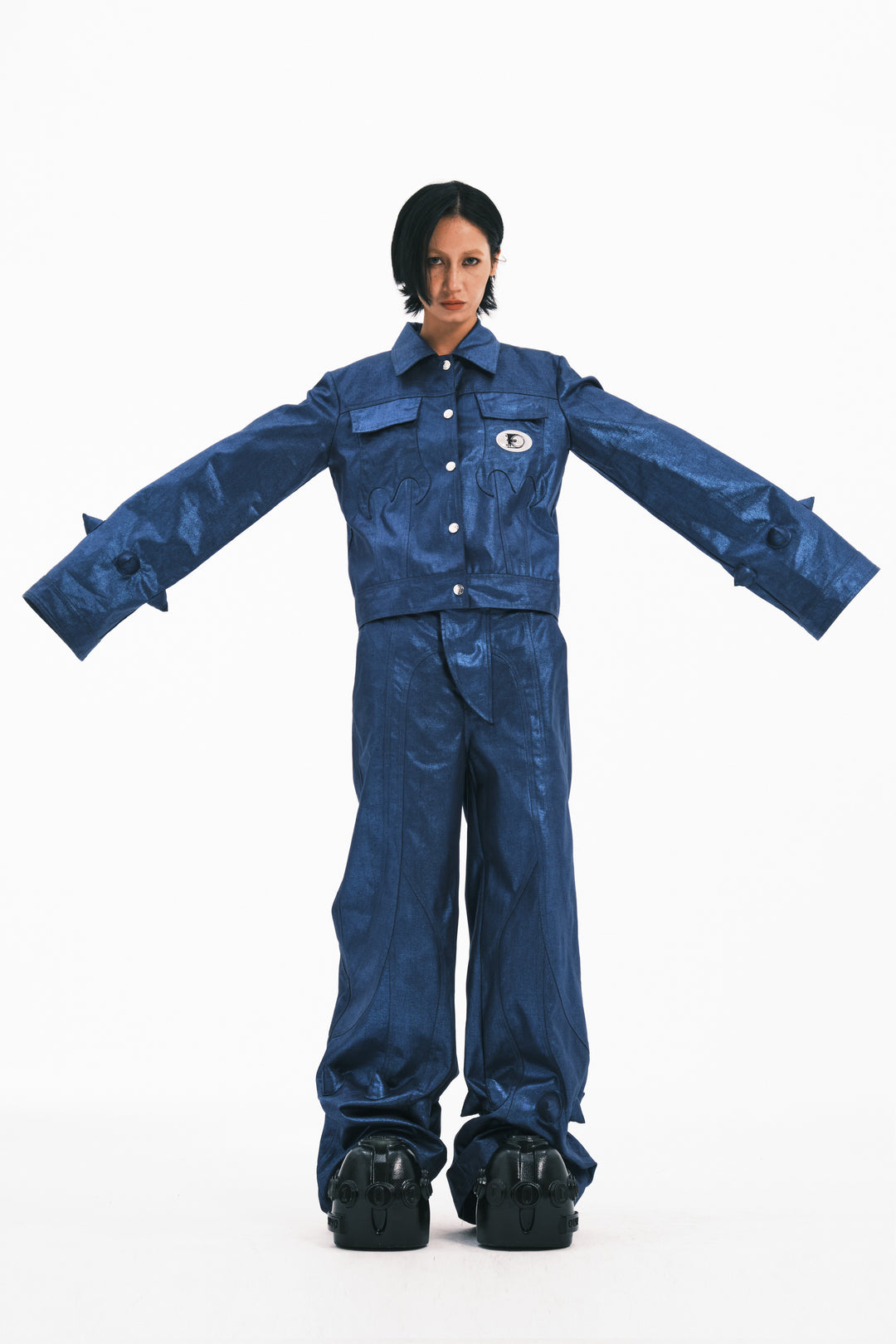 EMBRYO BLUE SPIKE metallic bell-sleeve jacket — blue front modeled view with arms extended to show wide bell sleeves