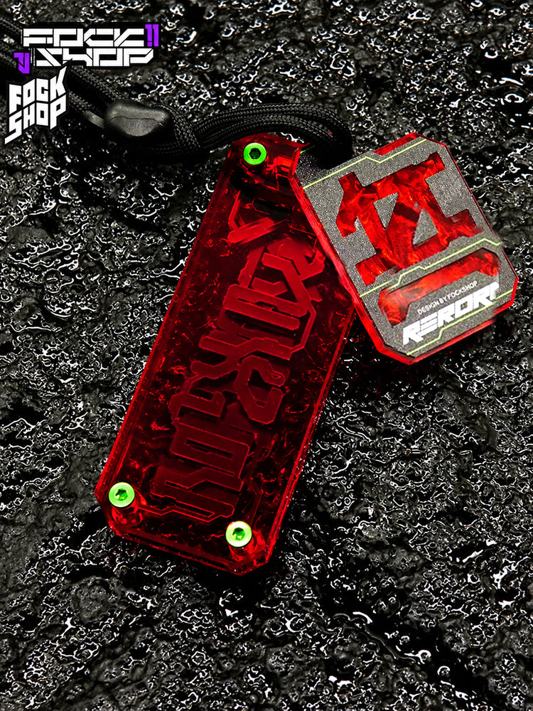 FOCKSHOP REBORN talisman charm — RED RIPPLE close-up showing the textured red backing and small plaque