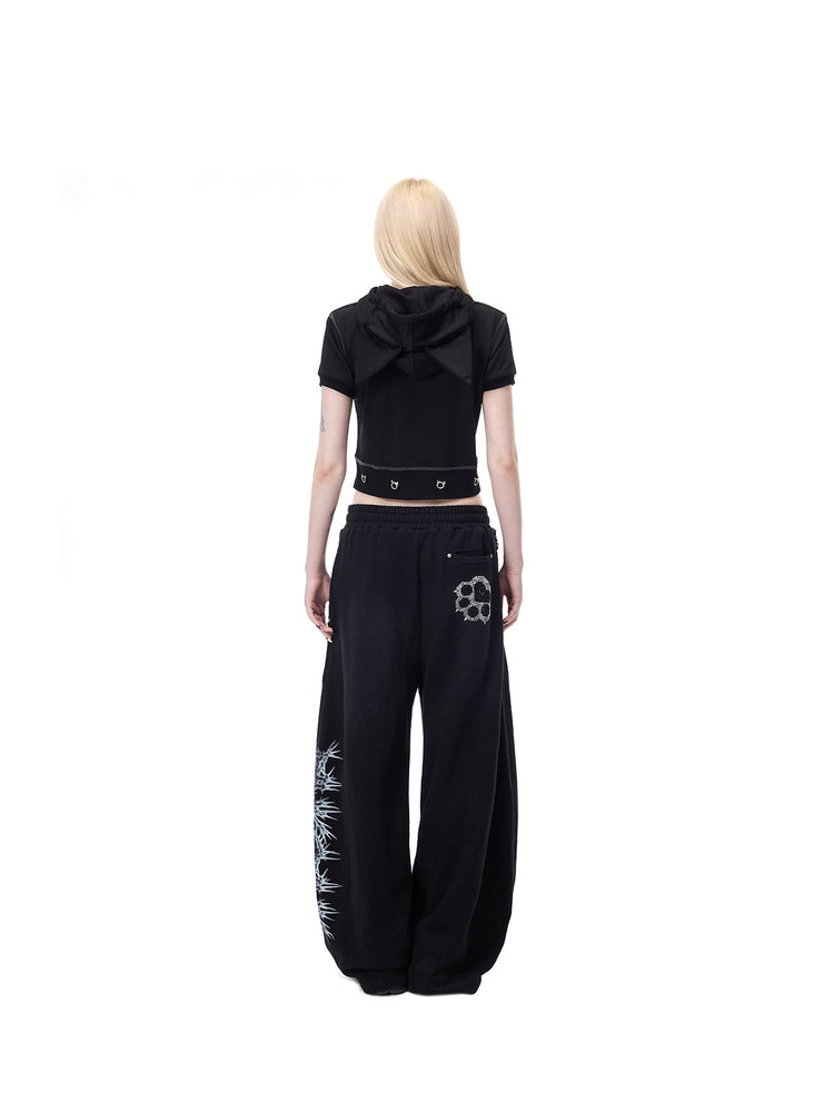 PINKSPINK CATPAW rhinestone curved-leg sweatpants in black — full-length rear modeled view showing the back paw and side thorn graphic