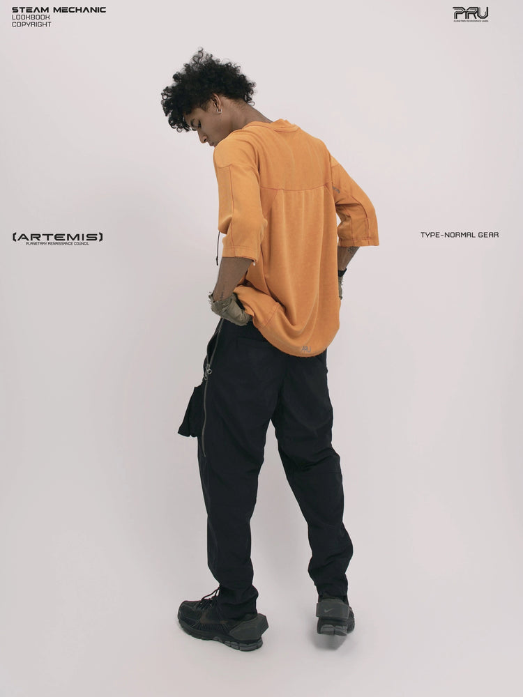 LIGHTSHADOW eclipse orange deconstructed technical tee — full-length back three-quarter view holding the hem