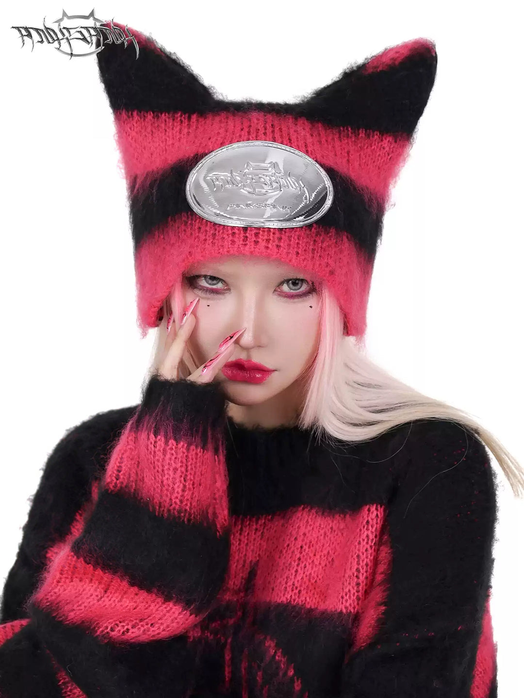 PINKSPINK SPHYNX striped cat-ear knit hat in black pink — front modeled close-up showing the pointed ears and silver-tone badge