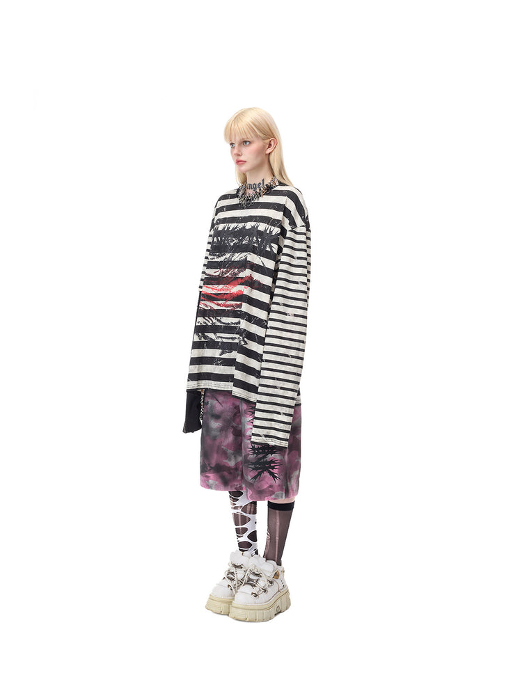 PINKSPINK STATIC asymmetric striped burnout long-sleeve tee in black and white — full-length side modeled view over separate pink camouflage shorts