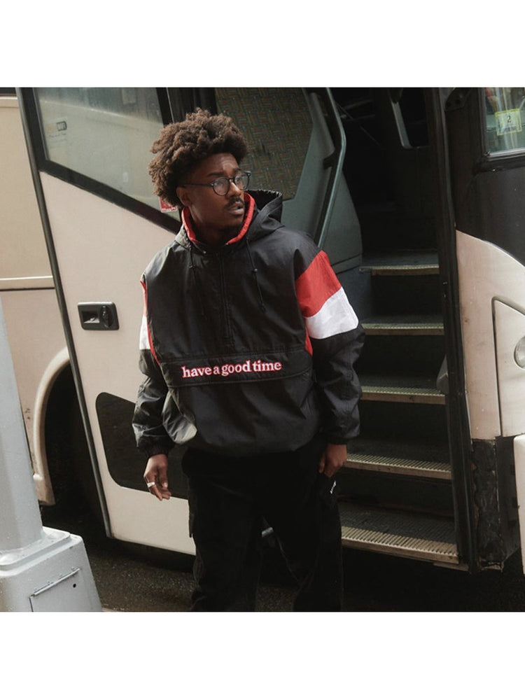 HAVE A GOOD TIME ANORAK jacket worn beside bus steps, showing the contrasting sleeve panels and loose fit