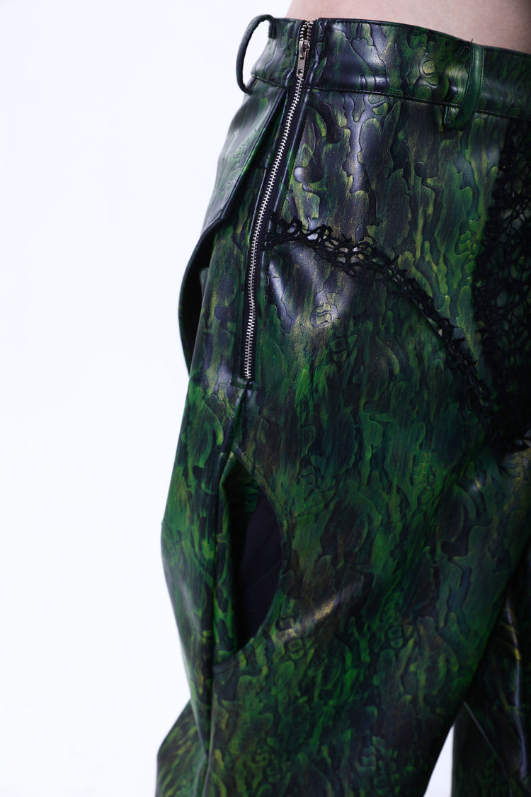 EMBRYO TRIANGLE ARMOR lace-inset leather pants in green — angled hip close-up showing the side zipper and curved pocket
