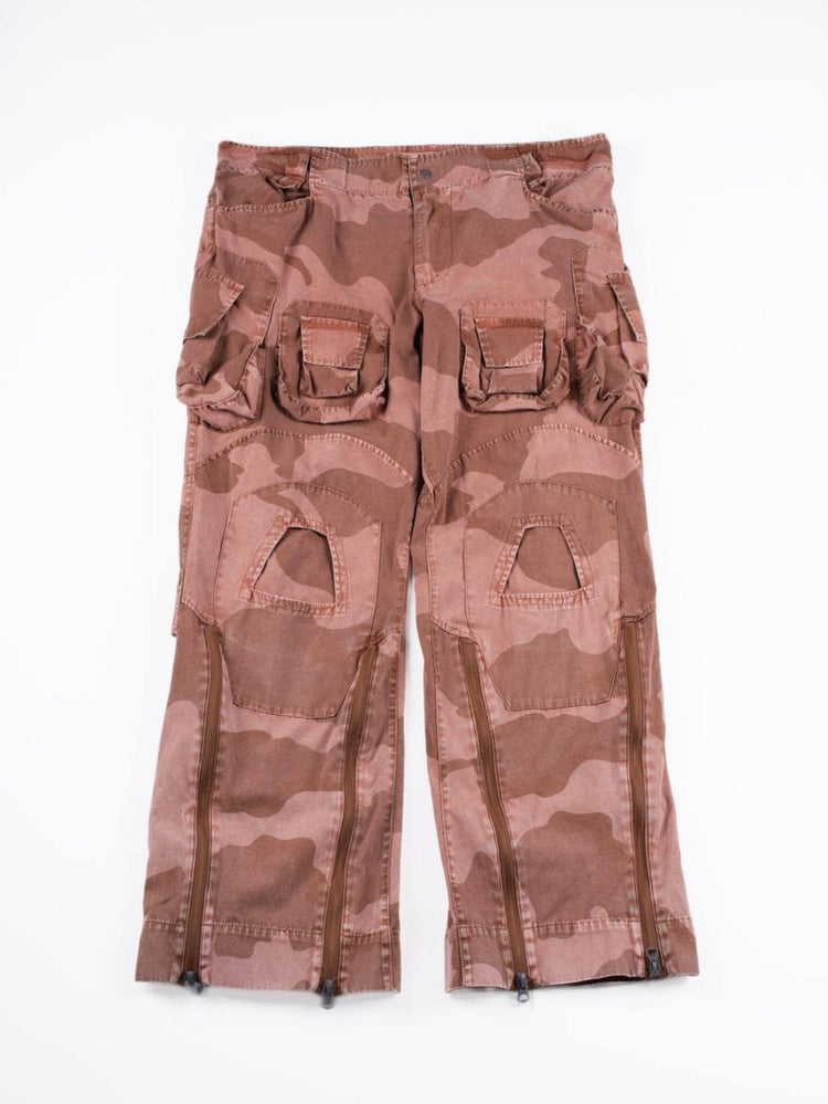 IXION washed camouflage combat pants in dune red — front garment-only flat-lay with lower-leg zippers closed
