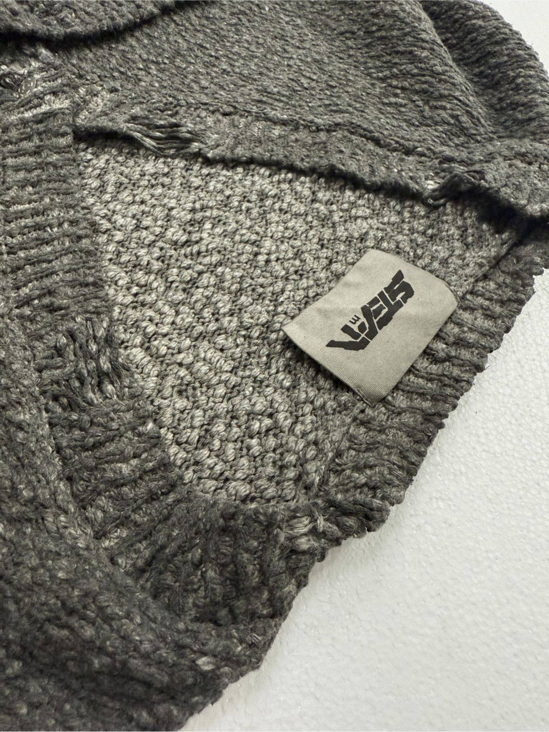 PIONEER moon dust gray moon-protection distressed sweater — close-up of the V-neck ribbing and sewn STEAM brand label
