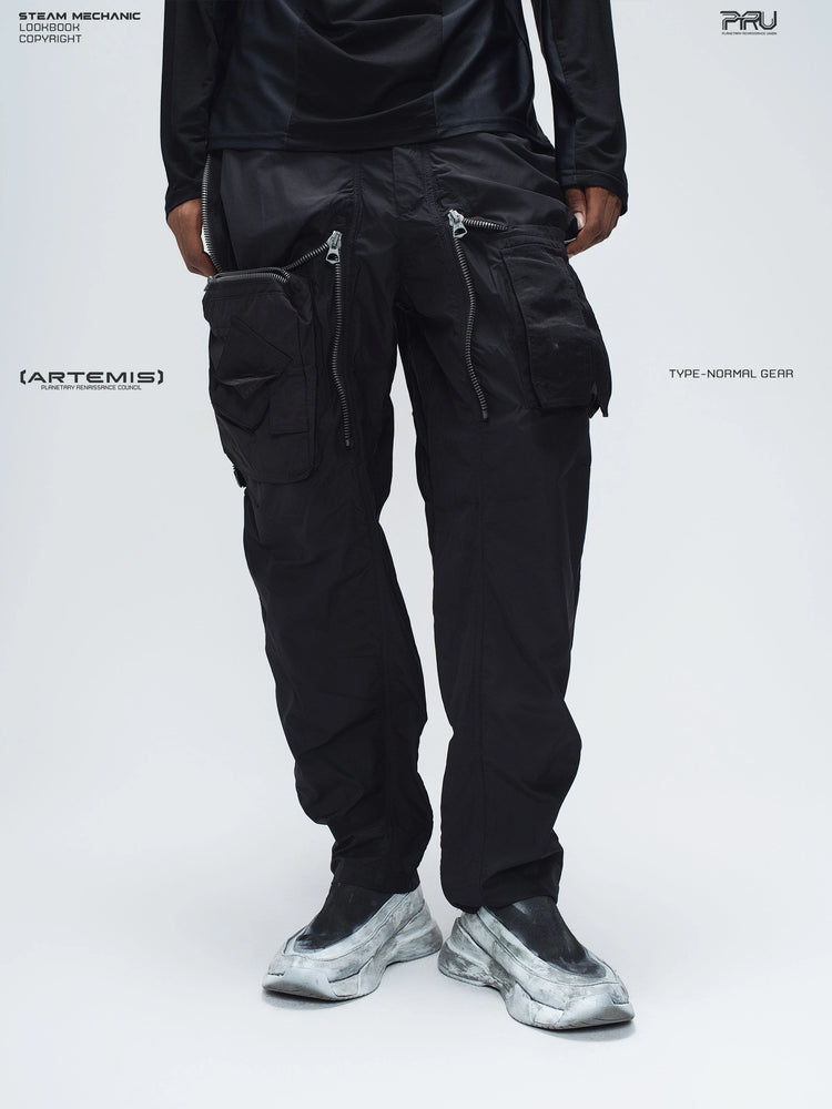 GAIA black curved-blade technical pants — front modeled view with the zip overlays opened to reveal utility pockets