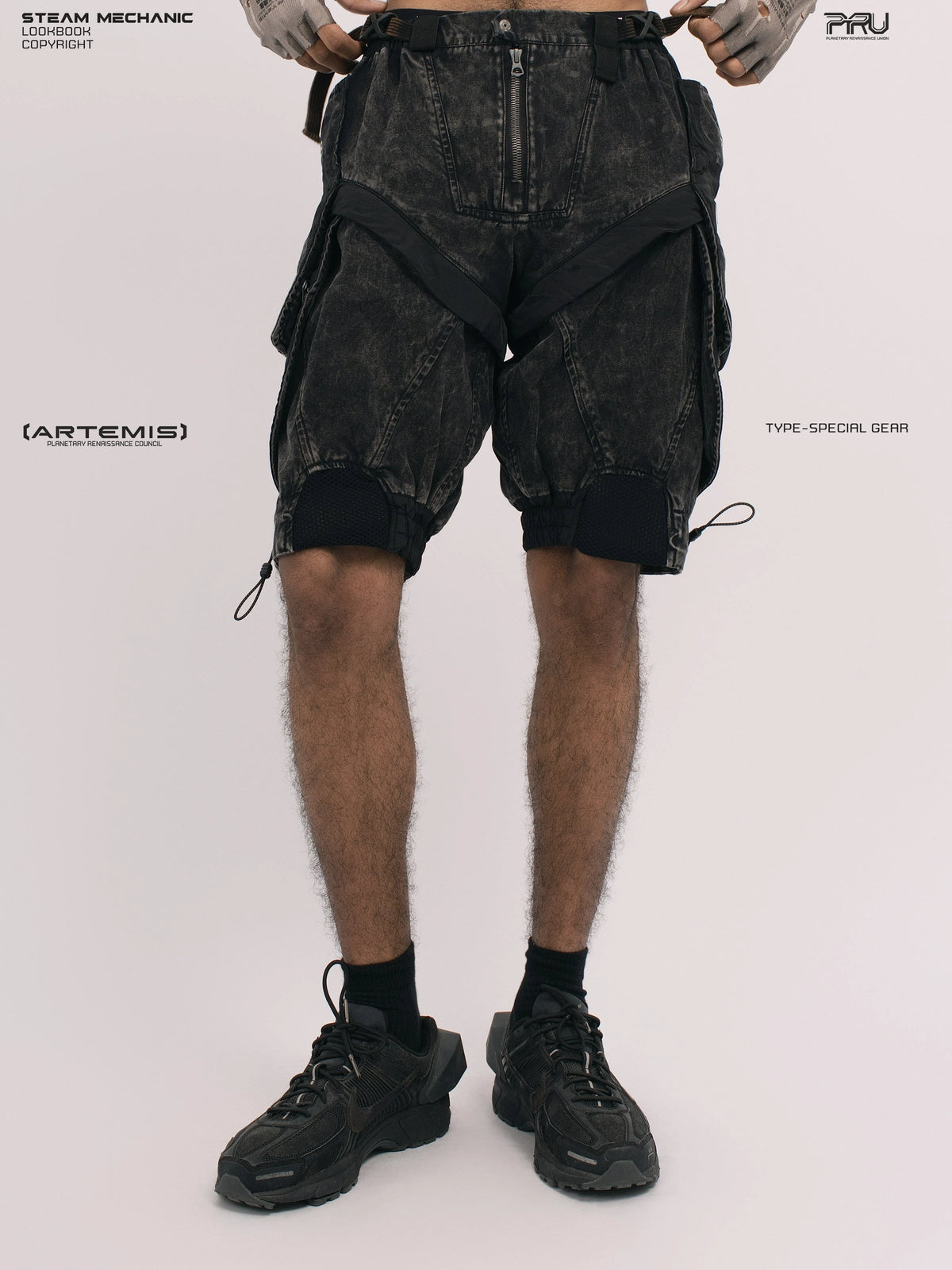 ARTEMIS blackbird black detachable technical shorts — front view with gloved hands at the waist