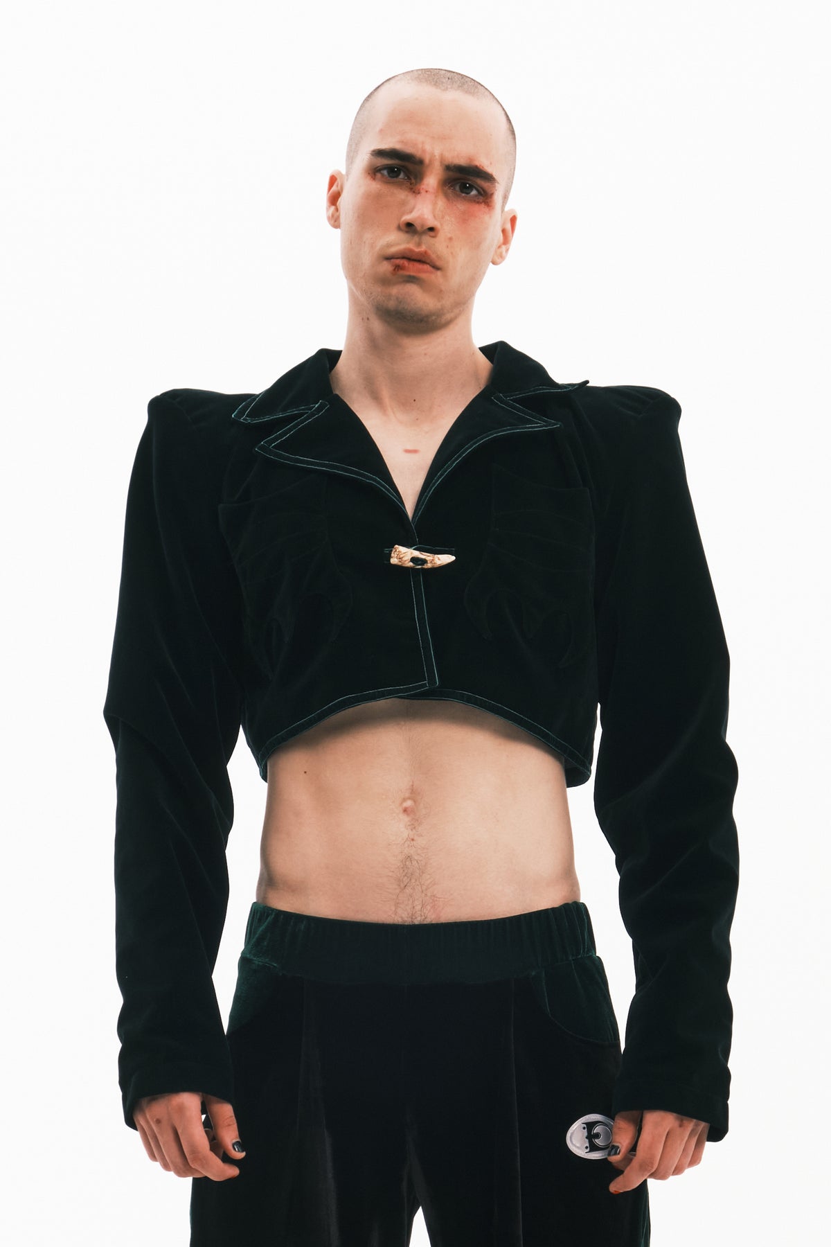 EMBRYO GREEN HORN cropped velvet blazer in dark green — front modeled view showing the cropped hem and broad shoulders