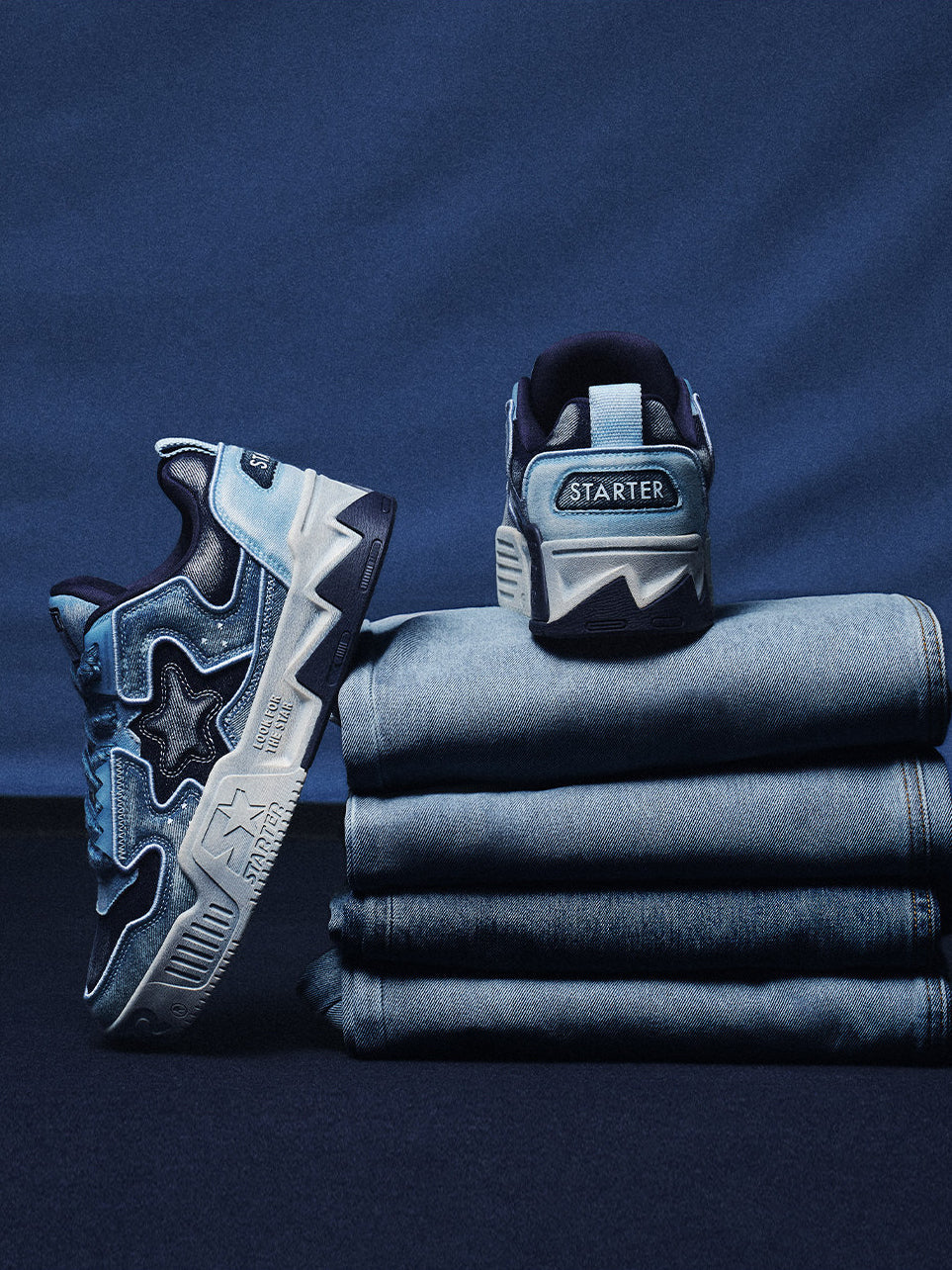 STARTER VOL 90S Denim Blue sneakers displayed on folded jeans, side and heel views