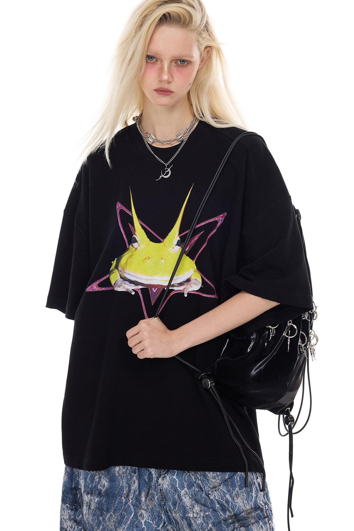 PINKSPINK HORNED FROG oversized graphic tee in black — three-quarter modeled close-up with a shoulder bag