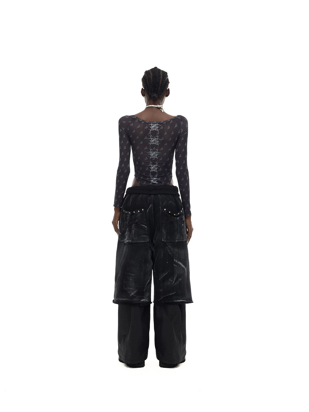 PINKSPINK MIRROR graphic mesh bodysuit in black — rear full-length modeled view with trousers