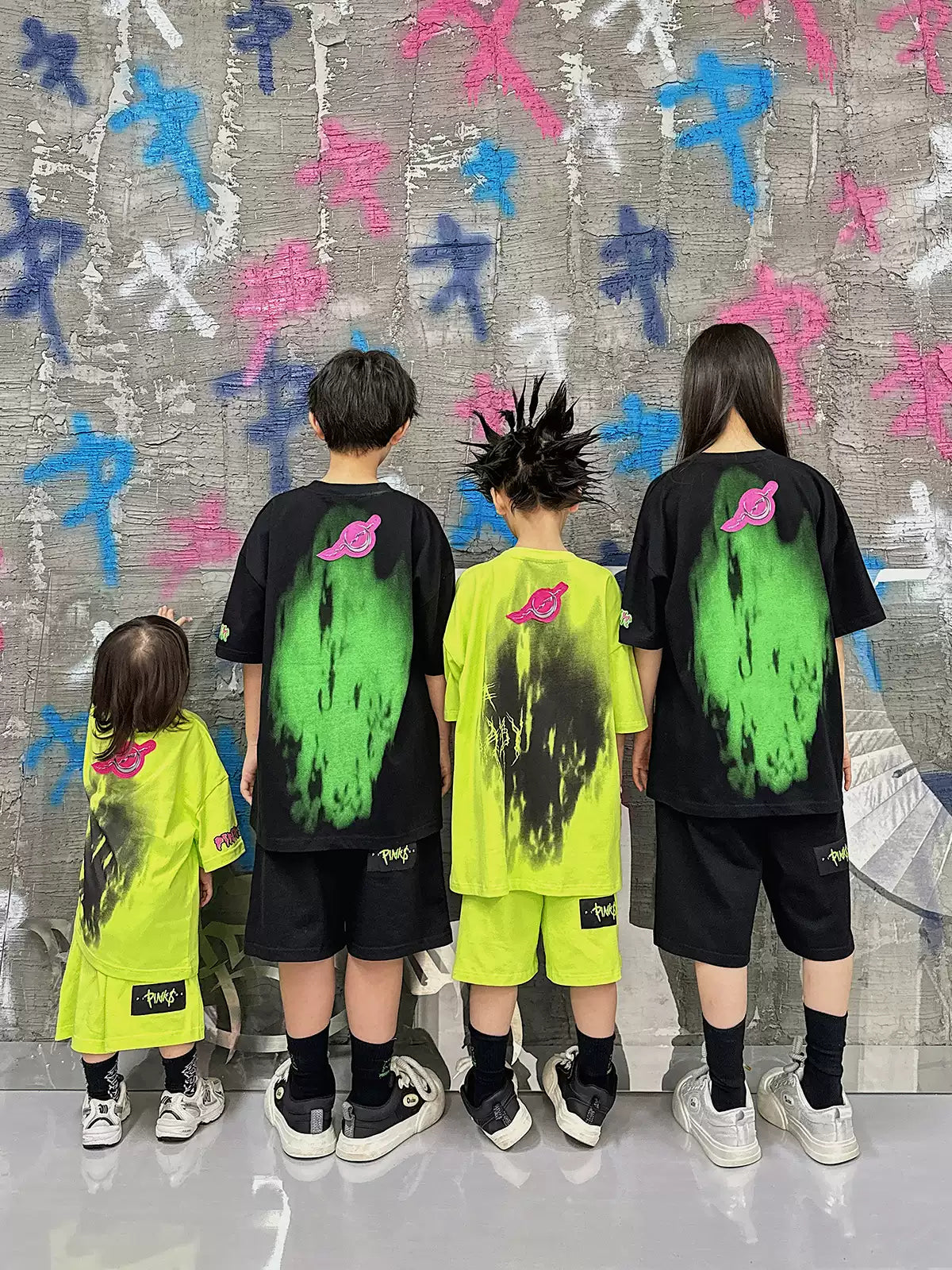PINKSPINK COLLISION kids graffiti tee and shorts set — group modeled back view showing the graffiti graphics