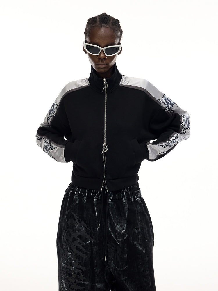 PINKSPINK MIRROR silver-panel zip jacket in black and silver — front modeled close-up with hands in the pockets