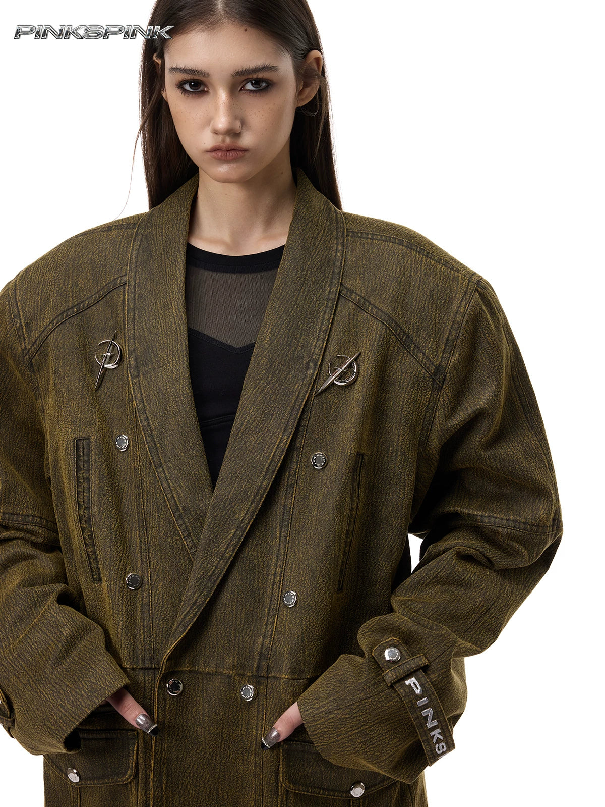 PINKSPINK ELECTRIC MOON sculpted-shoulder washed blazer in olive brown — front modeled close-up showing curved seams and silver-tone emblems