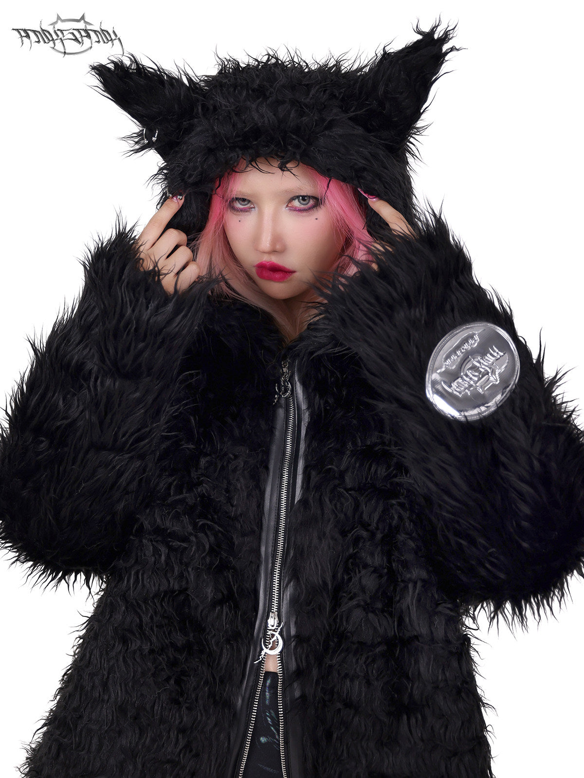 PINKSPINK DEVIL CAT pierced faux-fur jacket in black — close-up of the pierced cat-ear hood with hands at the temples