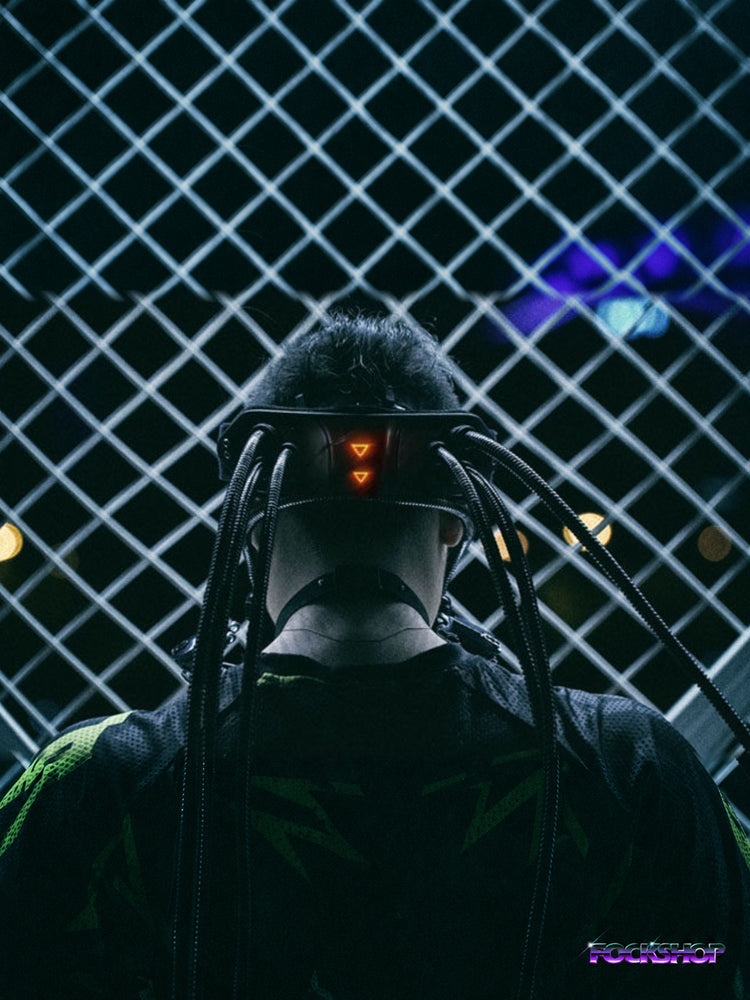 FOCKSHOP CTHULHU tube-detail cyber goggles — rear night portrait with goggles worn as a headband against a chain-link fence