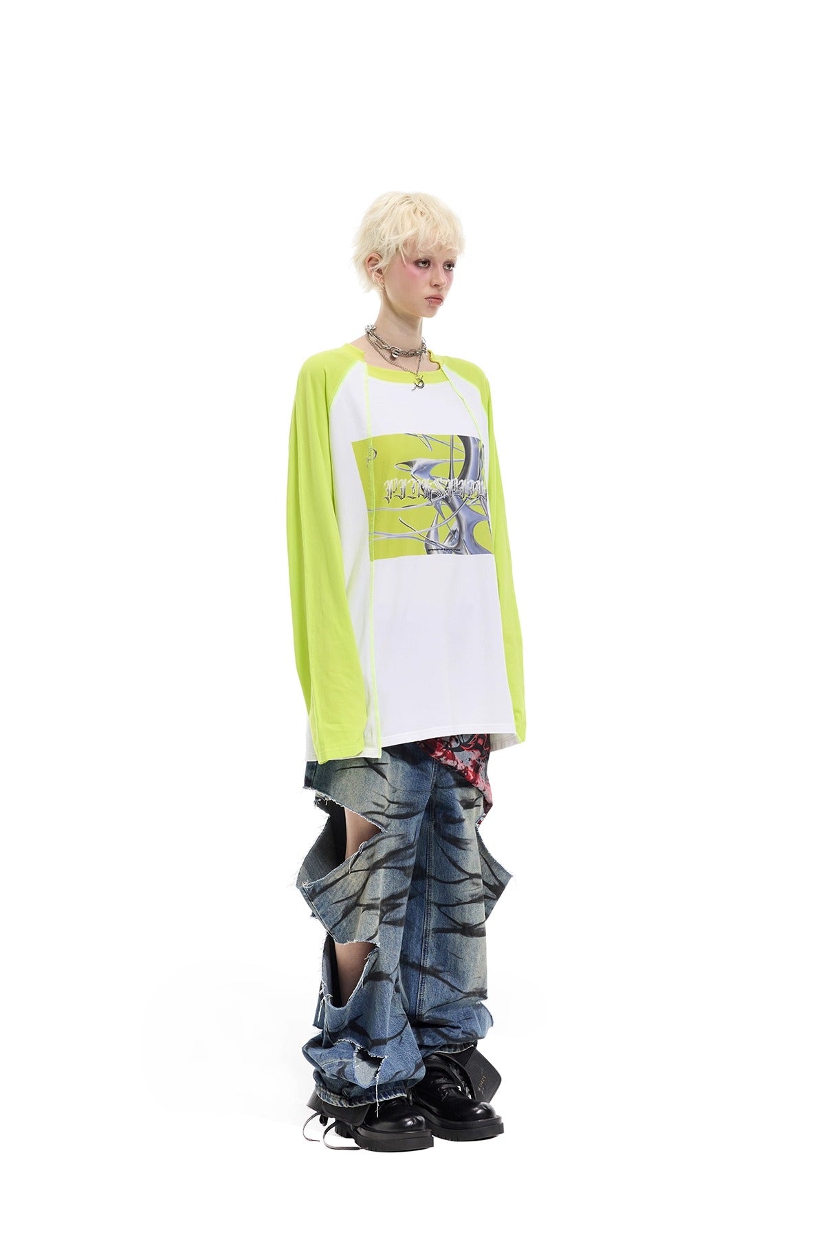 PINKSPINK REMAKE layered graffiti low-rise jeans in washed blue denim — modeled angled full-length view with lime-sleeve styling.