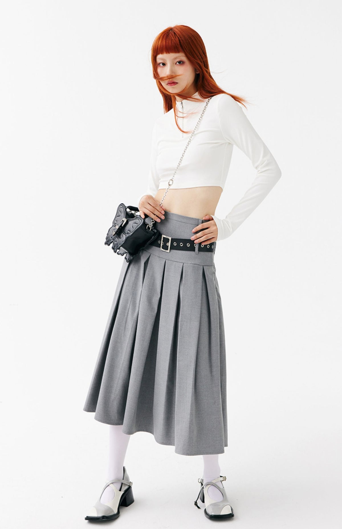 CIGABERRY butterfly-shaped faux-leather bag — black small chain bag with a white top and gray skirt, standing full-length view.