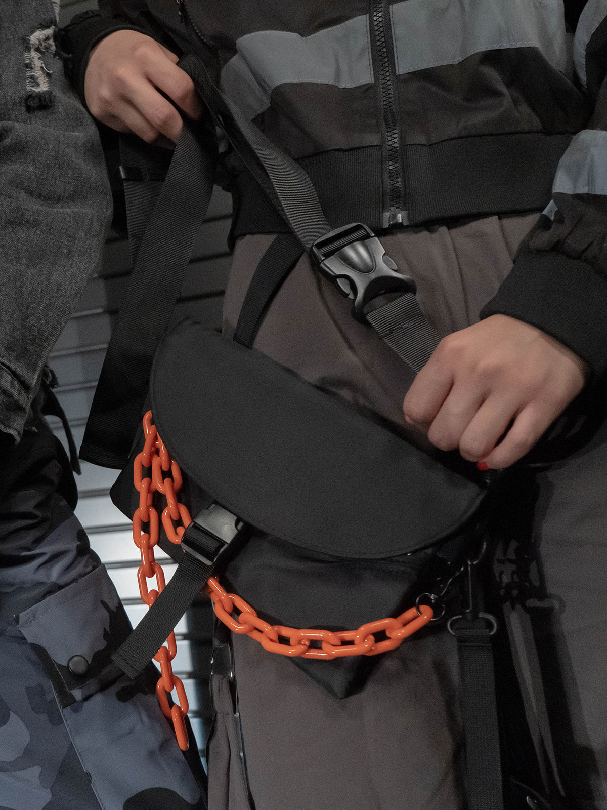 ORANGE BLACK bag, hand resting on the front flap