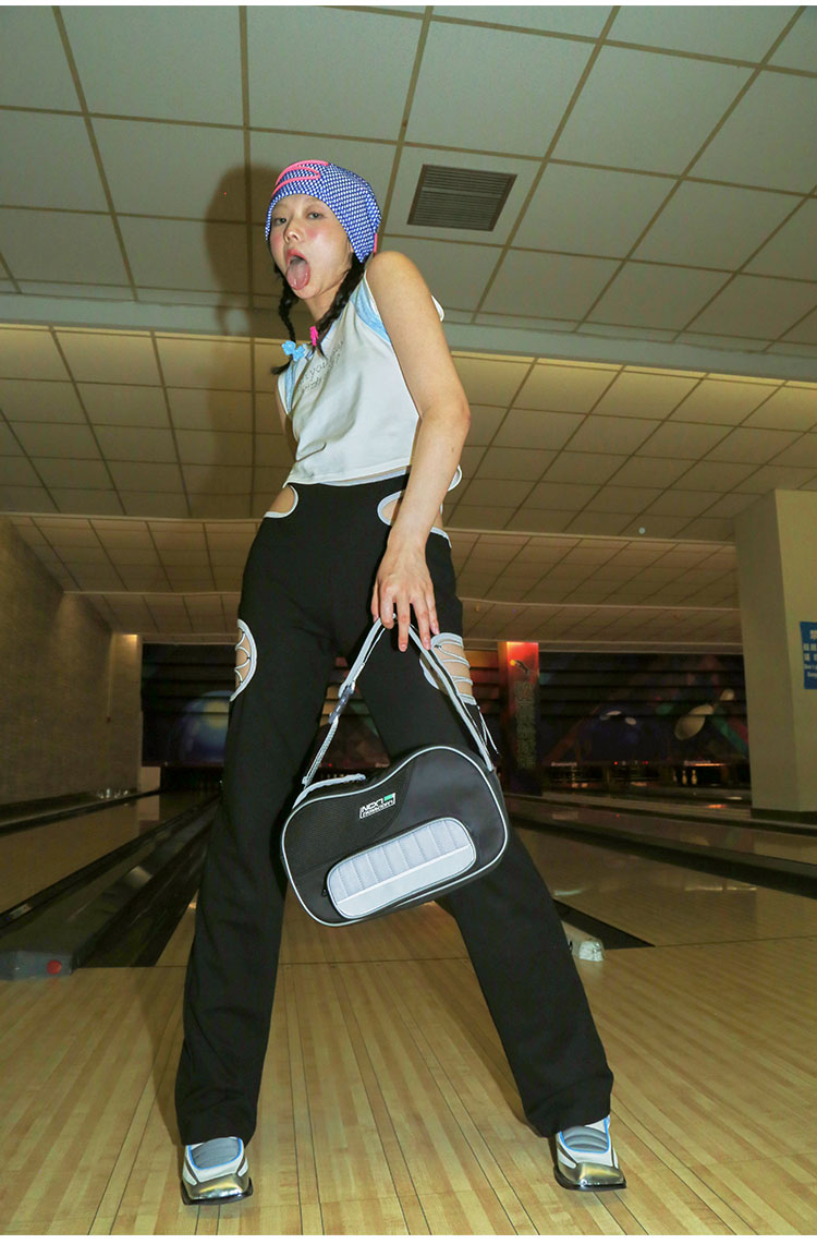 NEXT PASSPORT RETROFUTURE cutout pants, standing bowling-lane outfit with a shoulder bag