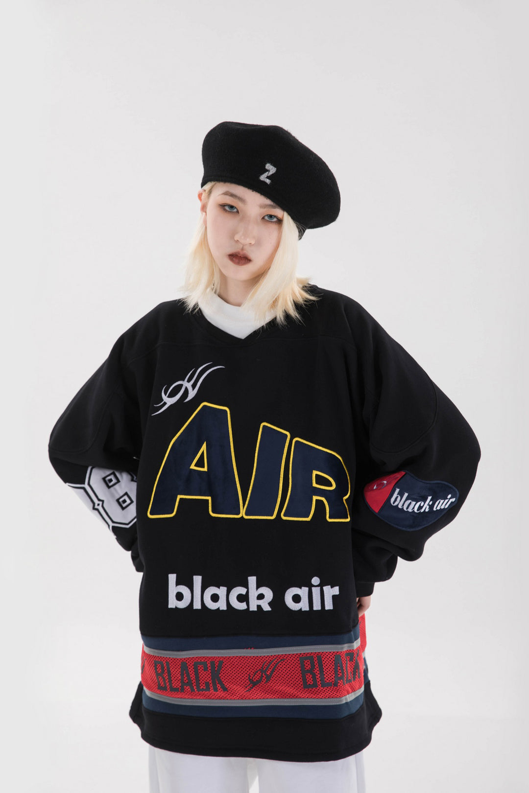 BLACKAIR varsity-letter sweatshirt, black, close hands-at-hips pose