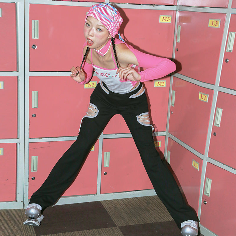 NEXT PASSPORT RETROFUTURE cutout pants, full front pose against pink lockers