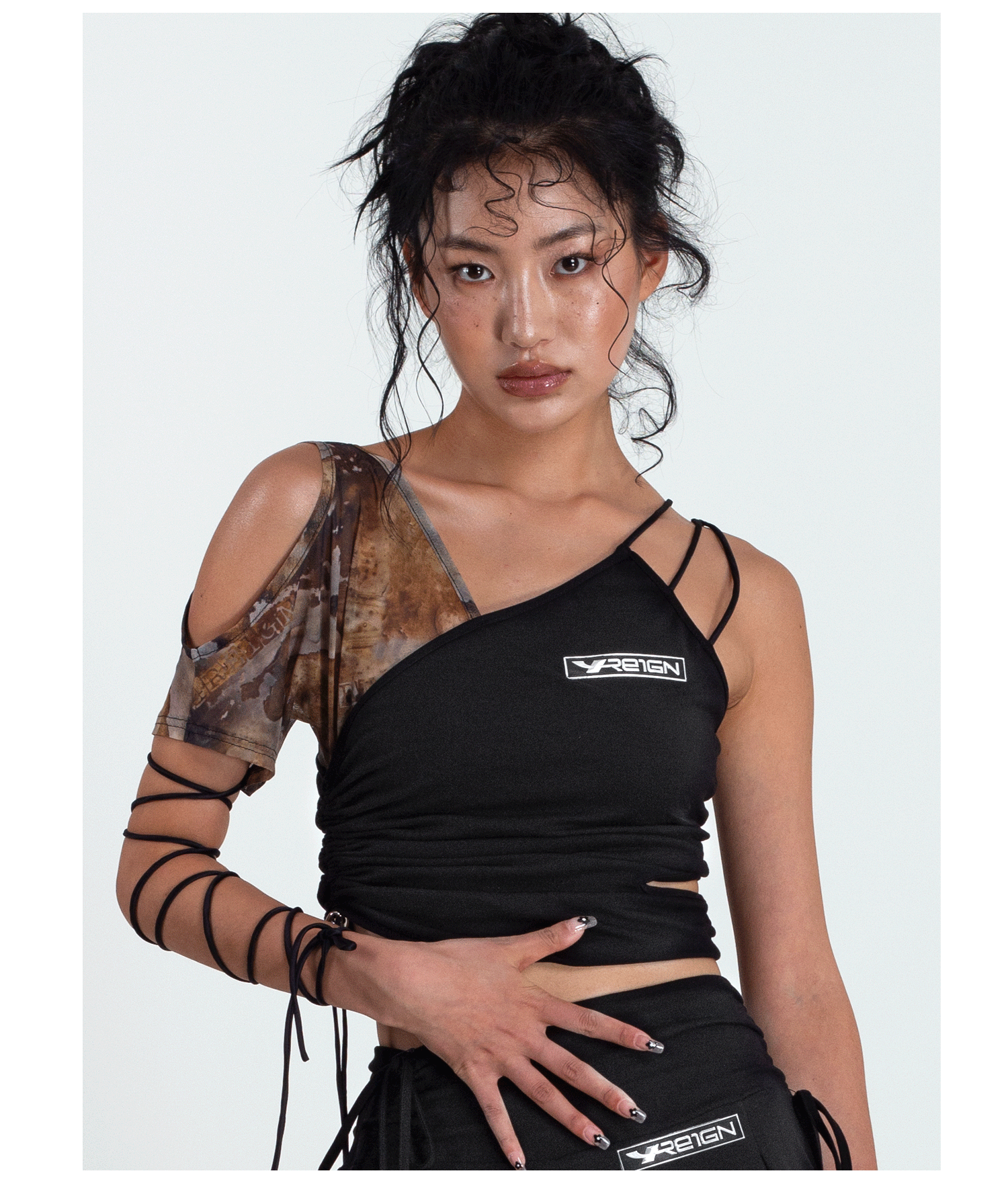 4RE1GN TIE-DYE SLEEVE asymmetric crop top, front pose with a hand at the waist